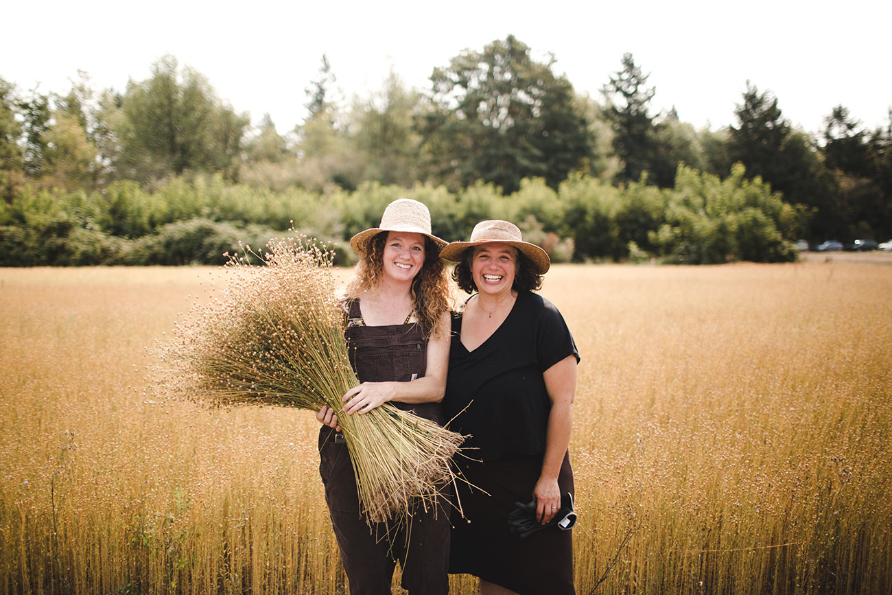 Shannon Welsh and Angela Wartes-Kahl with their 2017 flax crop at harvest time. Photograph by Micah Fischer