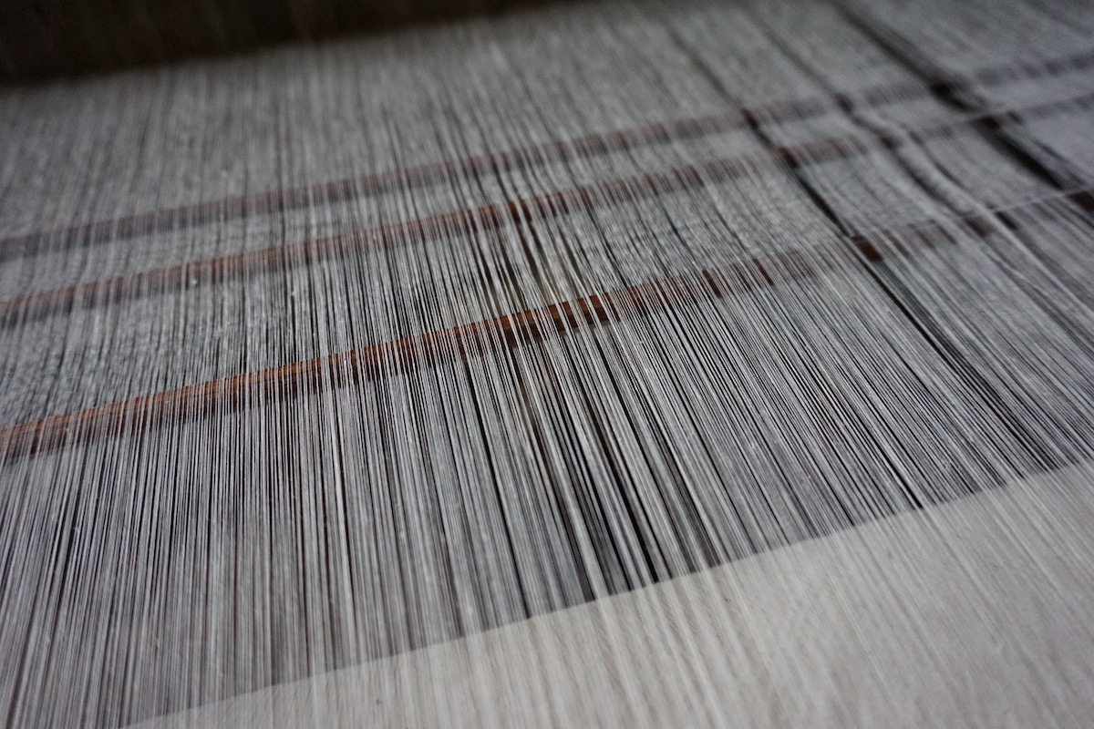 A close up of a wooden handloom used to weave the renowned intricate Bengali muslin fabric, which used to be, at 2,500 thread count, the finest cotton fabric in the world.