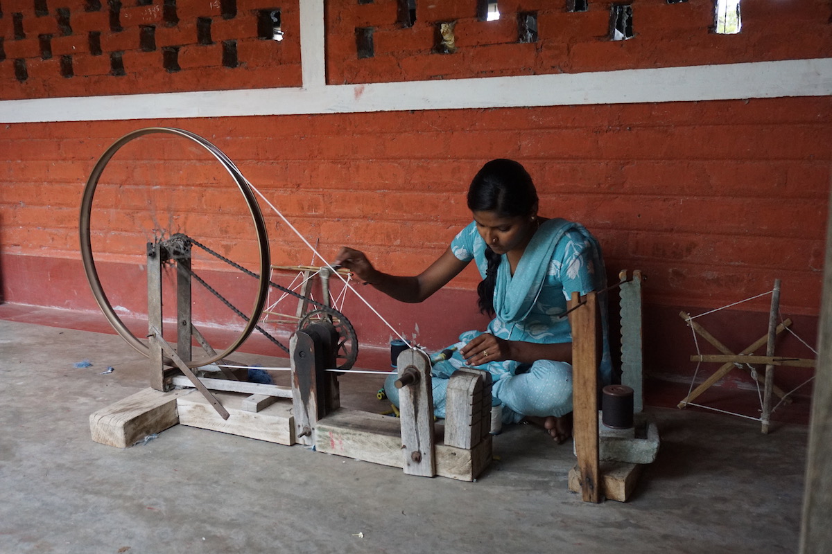 Handspinning of cotton using a recycled bicycle wheel at the Janapada Seva Trust.