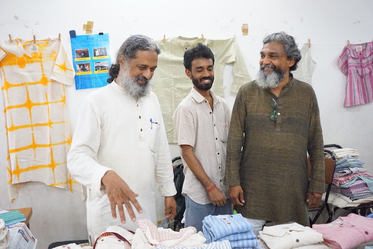 The Tula team staffing an exhibition in New Delhi_ Ananthoo, left, with two Tula volunteers surrounded by Tula clothing. Photo credit_ Harpreet Singh