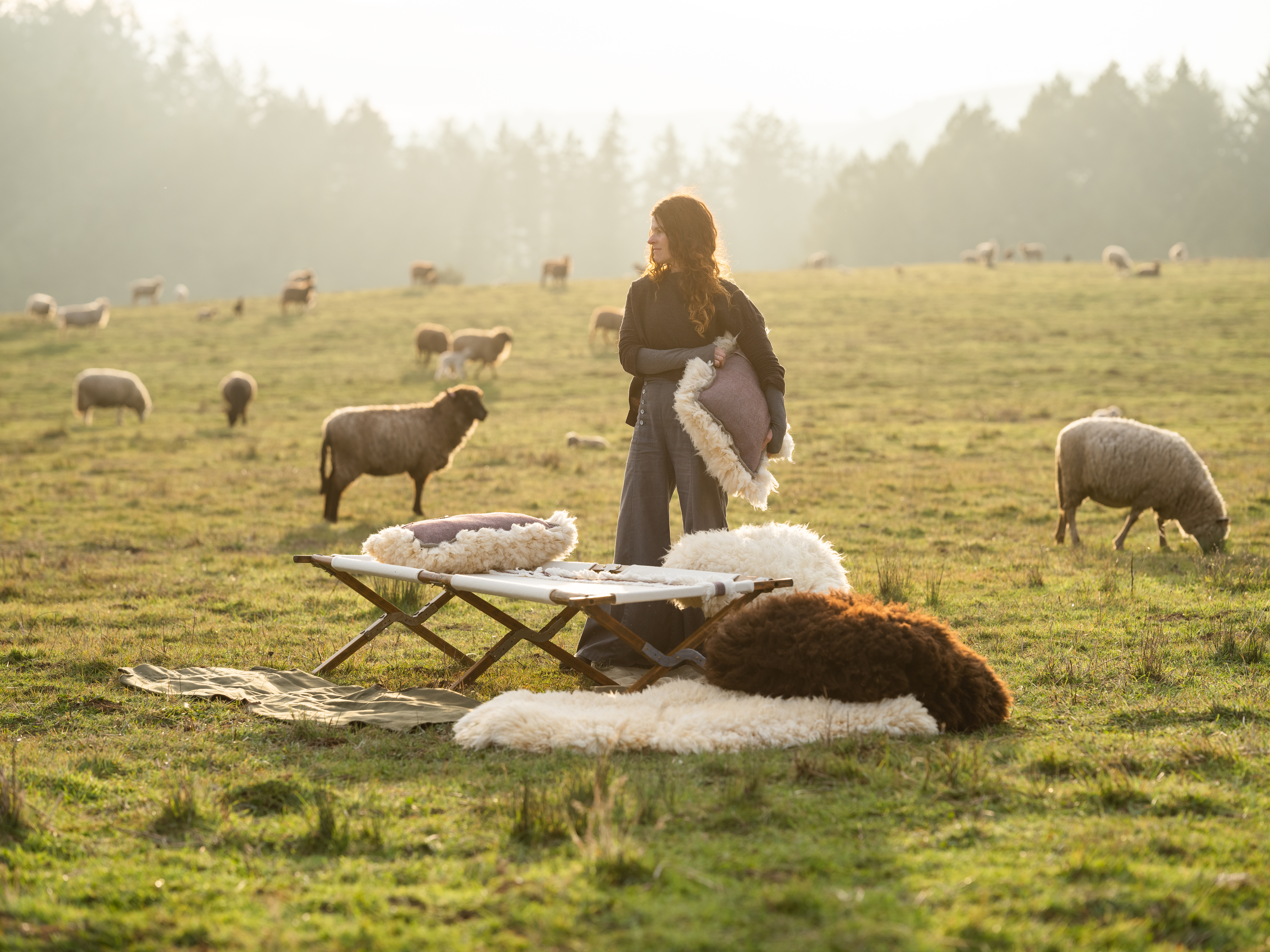 Photo of Beth Miles in a field with sheep in the background